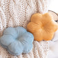 light blue and mustard yellow flower pillow on a sofa with a blanket