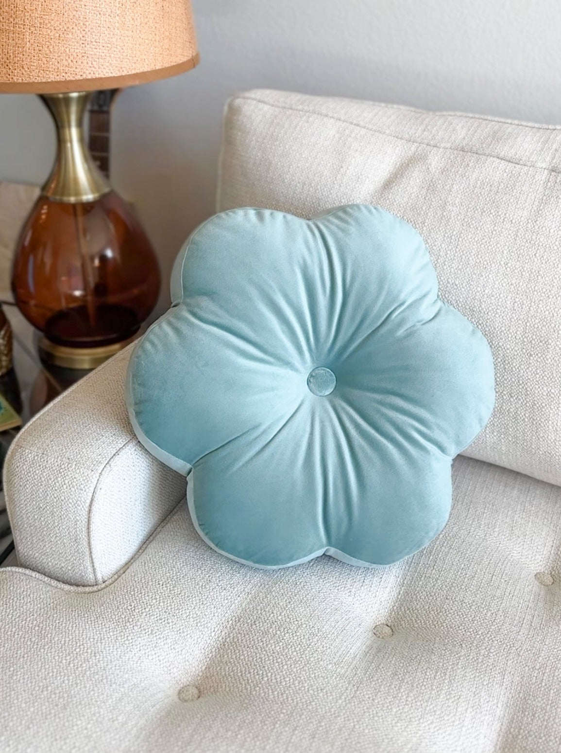 light blue flower pillow on a sofa