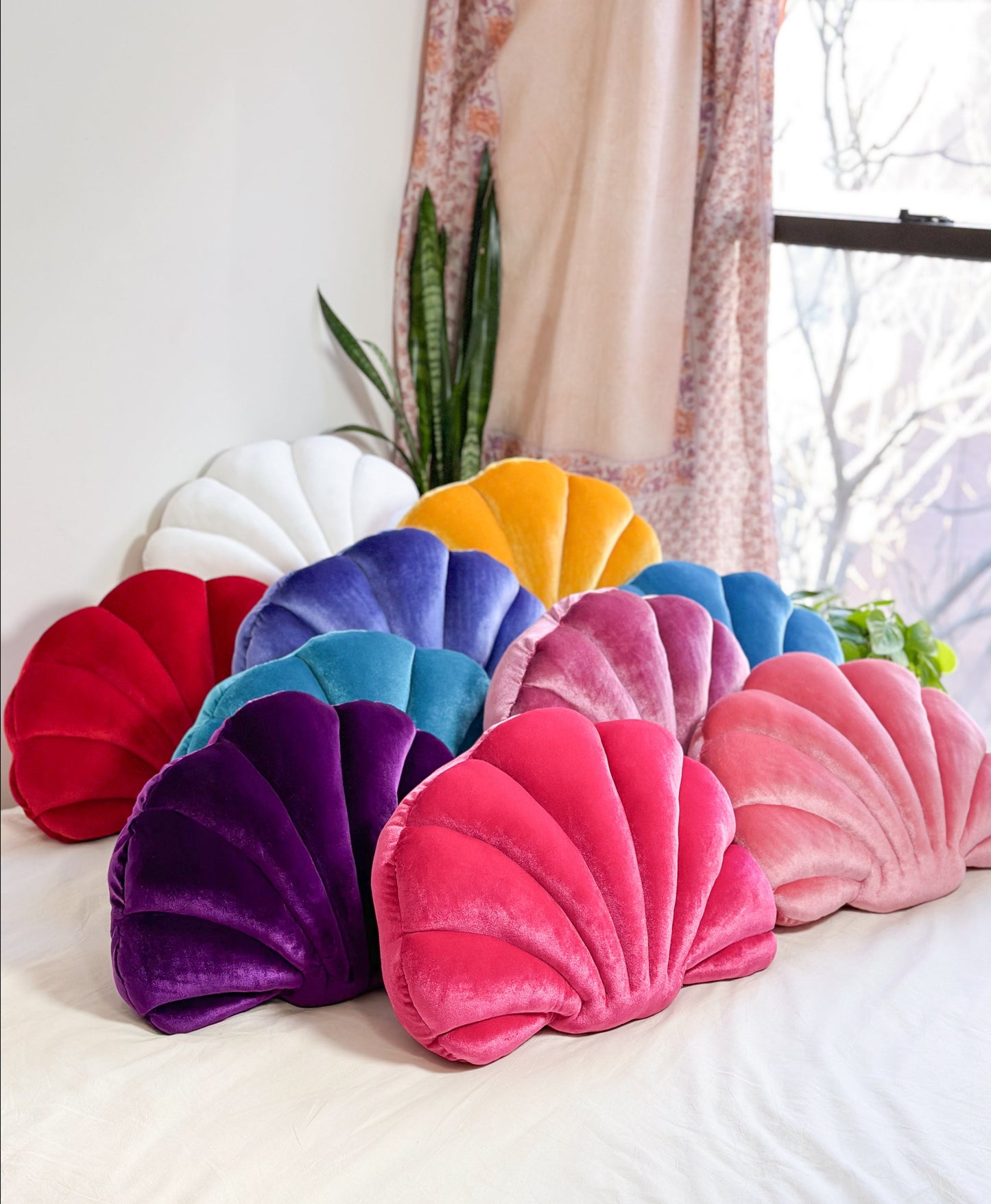 colorful shell shaped pillows on a bed